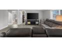 Comfortable living room with grey walls and floors, a large television, and reclining leather sofas at 3331 Fall Valley Dr, Columbus, IN 47203