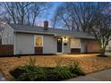 Charming exterior featuring horizontal siding, trimmed windows, a front door wreath, and manicured landscaping at 3415 N Wittfield St, Indianapolis, IN 46235
