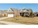Beautifully landscaped brick home boasting an attached garage, mature trees, and cozy front porch at 3982 Abbotsford Dr, Westfield, IN 46074
