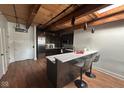 Modern kitchen with a breakfast bar, stainless appliances, and wood beam ceiling at 430 N Park Ave # 510, Indianapolis, IN 46202