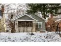 Charming two-story home featuring a covered porch and manicured front yard during winter at 5937 Broadway St, Indianapolis, IN 46220