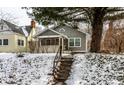Charming two-story home featuring a covered porch and manicured front yard during winter at 5937 Broadway St, Indianapolis, IN 46220