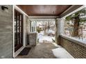Inviting covered front porch with brick columns, concrete floor, and a view of the neighborhood at 5937 Broadway St, Indianapolis, IN 46220