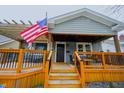 Inviting front porch featuring wood railings, an American flag, and a cozy seating area at 6047 Guilford Ave, Indianapolis, IN 46220