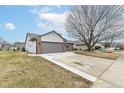 A single story home featuring attached garage with concrete driveway and green lawn at 7344 Quartz Rock Rd, Indianapolis, IN 46236