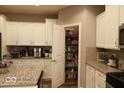 Bright kitchen featuring white cabinets, granite countertops, stainless steel appliances, and a well-organized pantry at 7349 Doyal Dr, Whitestown, IN 46075
