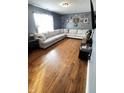Spacious living room with hardwood floors, a large sectional sofa, and natural light at 739 Quarterhorse Run, Bargersville, IN 46106