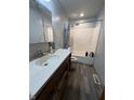 Bathroom featuring a combination shower and tub, updated wood-look flooring and a white vanity at 7643 S Delaware St, Indianapolis, IN 46227