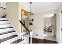 Inviting foyer featuring hardwood floors, stairs, and a view into a home office at 908 Whispering Trl, Greenfield, IN 46140