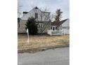 Home exterior with white picket fence, leads to a detached garage, and neat landscaping at 950 Ellenberger Pkwy West Dr, Indianapolis, IN 46219