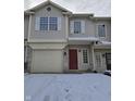 Two story townhome with a red front door and single car garage during the winter at 1017 Grovewood Dr, Beech Grove, IN 46107