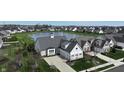 Aerial view of a grey home with lush landscaping and a serene pond at 10297 Anees Ln, Fishers, IN 46040