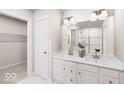 Bright bathroom with double vanity, white cabinets and a tiled shower at 1202 Brightwood Cir, Greenfield, IN 46140