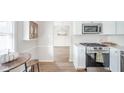 Modern kitchen boasts stainless steel microwave and gas range, white subway tile backsplash, and wood floors at 1718 Charles St, Anderson, IN 46013