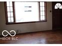 Sunlit living room featuring hardwood floors and large windows providing ample natural light at 305 Mohawk St, Anderson, IN 46012