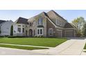 Stunning two-story home with brick and stone elevation, well-manicured lawn, and a paved driveway leading to a two-car garage at 3236 Willow Bend Trl, Zionsville, IN 46077