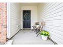 This covered porch has seating, decorations, and an inviting front entry door at 4619 Churchill Downs Cir, Greenwood, IN 46143