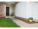 Inviting covered entry decorated with flower pots and an inviting wreath on the front door at 4619 Churchill Downs Cir, Greenwood, IN 46143