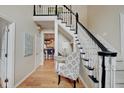A stylish foyer area featuring hardwood floors, and a staircase with a black handrail, leading to a home's upper level at 4754 Austin Trce, Zionsville, IN 46077