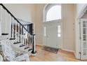 A bright foyer with hardwood floors and a striking staircase, complemented by a large window above the entry door at 4754 Austin Trce, Zionsville, IN 46077