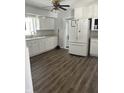 Traditional kitchen with white cabinets, laminate flooring, and view of the entry to the laundry room at 5139 S Keystone Ave, Indianapolis, IN 46227