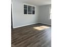 Bright living room with gray paint, modern laminate flooring, and ample natural light from two windows at 5139 S Keystone Ave, Indianapolis, IN 46227