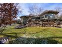 Expansive backyard showcasing lush lawn, mature trees, and elegant landscaping for outdoor enjoyment at 5400 W Deer Run Ct, Muncie, IN 47304