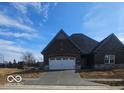 Attractive brick home featuring a two car garage, large front lawn, and freshly poured driveway at 6641 Stone Pointe Way, Indianapolis, IN 46237