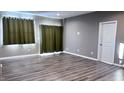 Bright living room featuring wood flooring, large windows, and neutral-colored walls at 673 Ballycastle Ct, Pendleton, IN 46064