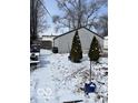 Snowy backyard view showcasing the detached garage and a glimpse of the outdoor space at 926 River Ave, Indianapolis, IN 46221