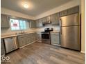 Well-lit kitchen with stainless steel appliances, gray cabinets, and modern flooring at 930 Park Central S Dr # 930C, Indianapolis, IN 46260