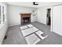 Living room featuring a fireplace, neutral paint, ceiling fan, and new carpeting at 102 Plummer Ave, Bargersville, IN 46106
