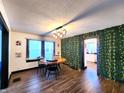 Bright dining room with wood flooring, decorative wall, modern lighting, and a view of the updated kitchen at 1042 Nelson Ave, Indianapolis, IN 46203