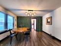 Stylish dining room featuring wood floors, decorative wall, modern lighting fixture, and round dining table at 1042 Nelson Ave, Indianapolis, IN 46203