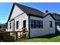 Back of house featuring updated landscaping, black trim and a well-kept lawn at 1042 Nelson Ave, Indianapolis, IN 46203