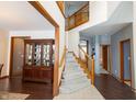 Bright foyer featuring a staircase with wood railings and a large china cabinet, leading to other rooms at 1136 Meriman Dr, Greenwood, IN 46143