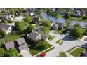 Aerial view of a suburban neighborhood with lush green lawns and a community pond at 1232 Severn Ct, Greenwood, IN 46142