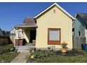 Charming yellow single Gathering home with a cozy porch and well-kept front yard, great curb appeal at 1640 Bellefontaine St, Indianapolis, IN 46202