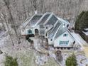 Aerial view of a charming brick two-story home with a dark roof and bright blue shutters surrounded by trees at 4388 Creekside Pass, Zionsville, IN 46077