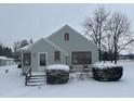 Charming home featuring gray siding, red trim, and inviting front porch in winter at 504 E Walnut St, Summitville, IN 46070