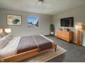 A cozy bedroom featuring neutral walls, a queen bed, and a natural wood dresser at 6462 Zionsville Rd, Indianapolis, IN 46268