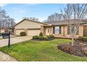 Inviting exterior view of brick home with a well-maintained lawn and double garage at 8429 Quail Hollow Rd, Indianapolis, IN 46260