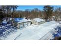 Aerial view of the home with large detached garage, set on a snow-covered lot with surrounding trees at 9800 N Gasburg Rd, Mooresville, IN 46158