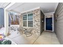 Cozy front porch with seating and brick accents, leading to a dark blue front door at 10178 Bolcom Ct, Noblesville, IN 46060