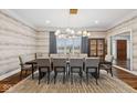 Dining room featuring stylish light fixture, designer wallpaper, large table, and hardwood floors at 11120 Queens Way Cir, Carmel, IN 46032