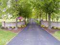Long driveway with American flag, leading to a stately home with a gated entrance and tree-lined landscape at 12484 E 156Th St, Noblesville, IN 46060