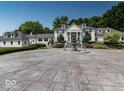 Stately white home featuring columns, a circular driveway, an elegant fountain, and meticulously manicured landscaping at 12484 E 156Th St, Noblesville, IN 46060