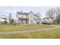 Well-maintained two-story home with a manicured lawn, charming front porch, and convenient two-car attached garage at 1501 Willshire Dr, Greenwood, IN 46143