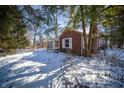 Charming brick home with a snow-covered yard and mature trees at 1701 Broad Ripple Ave, Indianapolis, IN 46220