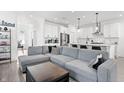 Spacious living room featuring a comfortable gray sofa and a glimpse of the modern kitchen at 1842 Milburn St, Indianapolis, IN 46202